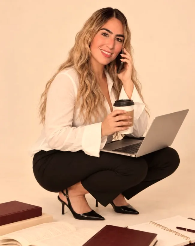 Camila Cachutt sentada con una laptop y una taza